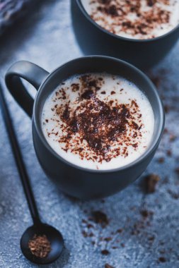 Gri arka planda bir fincan sıcak kakao, hygge tarzı, yakın plan.