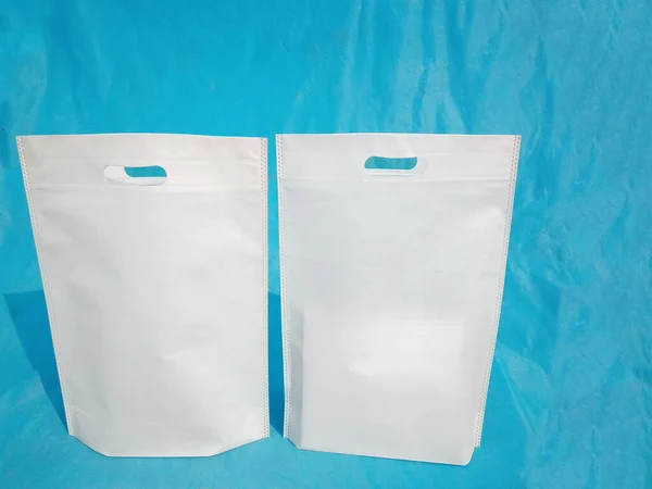 non woven fabric grocery bags on blue background. ECO Friendly Tote promotional products shopper bags