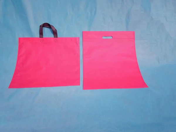 non woven fabric grocery bags on blue background. ECO Friendly Tote promotional products shopper bags