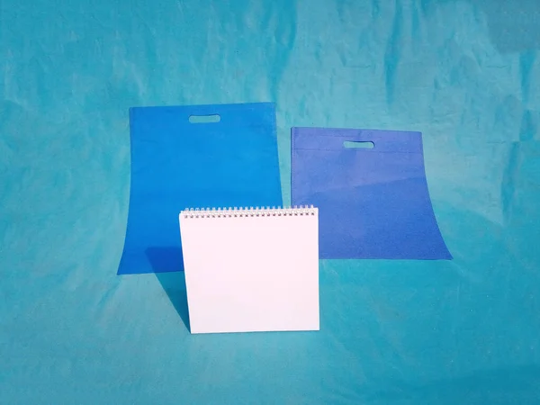 non woven fabric grocery bags on blue background. ECO Friendly Tote promotional products shopper bags