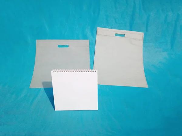 non woven fabric grocery bags on blue background. ECO Friendly Tote promotional products shopper bags