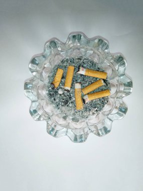 Beyaz arka planda bir yığın sigara yakın plan. Tütün organizmaya sayısız zarar verebilir..