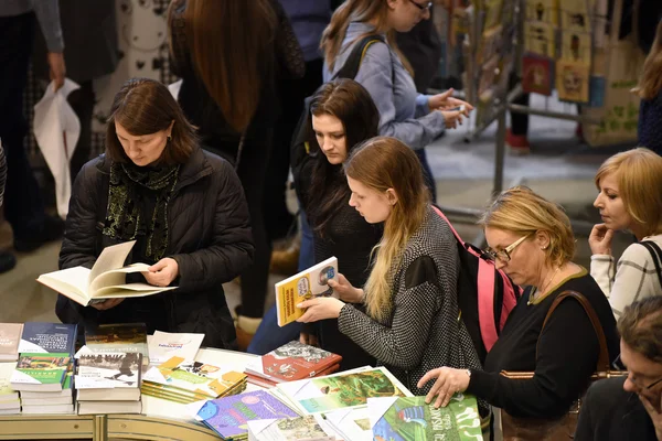 Люди выбирают книги на книжном рынке — стоковое фото