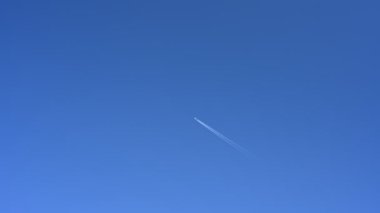Mavi gökyüzüne karşı seyir halinde olan yolcu uçağı.