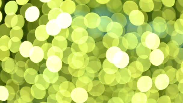 浅黄和绿色的模糊的Bokeh 闪烁着光芒的运动 就像圣诞节的光芒 — 图库视频影像