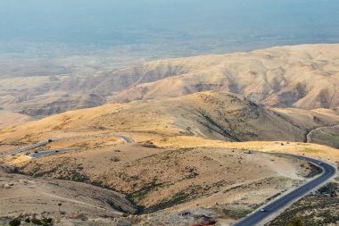 Ürdün 'deki İncilsel Nebo Dağı' ndan günbatımı ışıklarıyla manzara. Musa 'nın vaat edilmiş toprakları Ürdün çöl vadisinde gördüğü Nebo Dağı' nın tepesinden manzarayı seyret.