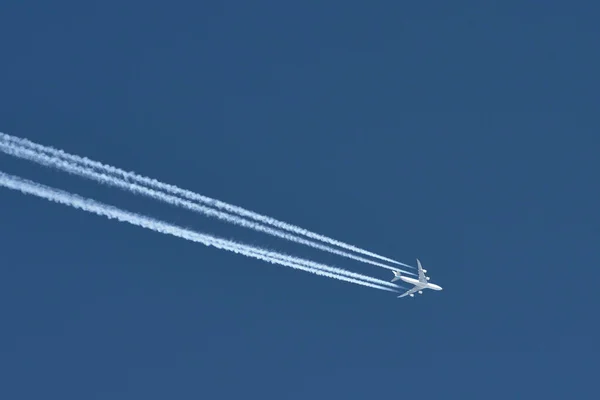 Airplane In Blue Sky With Plane Trails