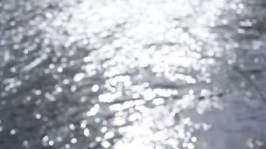 Bokeh güneşi su yüzeyine yansıyor. Güneş ışınları su akıntısında titreşiyor.. 