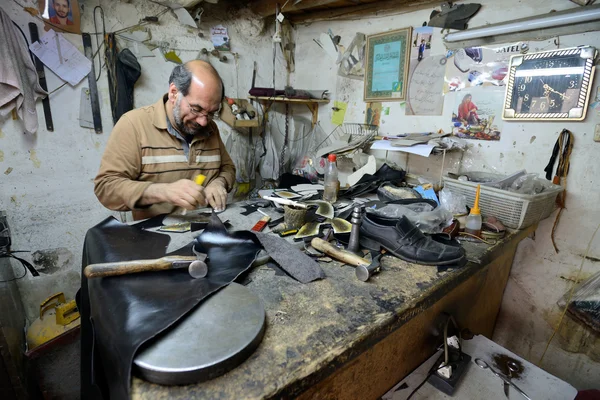 Homme faisant des chaussures dans un marché — Photo