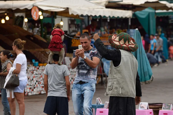 Mensen met aap op Djemaa el Fna plein — Stockfoto