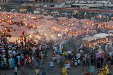 İnsanlar Jemaa el Fna Meydanı batımında ziyaret.