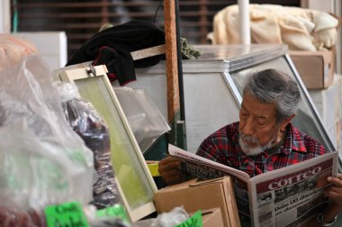 San Miguel de Allende, Meksika - 8 Temmuz 2023: Tanımlanamayan adam şehir pazarında gazete okuyor. San Miguel de Allende, Meksika 'da..