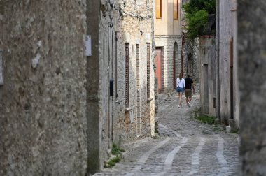 Sicilya 'nın eski Catania kasabasında insanlar dar bir sokakta yürür.