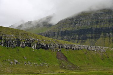 Sisli dağ zirveleri, denizi ve dağları kaplayan bulutlar. Ünlü bir yerden manzara - Sornfelli Streymoy Adası, Faroe Adaları,
