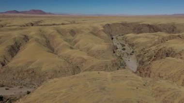 Namibya 'da bir kanyon. Granit kayalıklar deniz gibi bükülür. Drone görünümü.