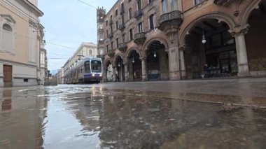 Torino, İtalya - 25 Aralık 2025: İtalya 'nın Piedmont bölgesinde eski şehir merkezi Torino durin yağmurunda eski tramvayla sokak manzarası