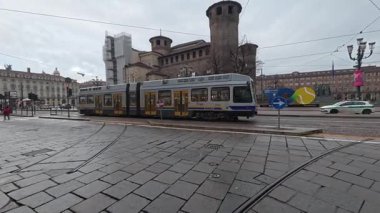 Torino, İtalya - 25 Aralık 2025: İtalya 'nın Piedmont bölgesinde eski şehir merkezi Torino durin yağmurunda eski tramvayla sokak manzarası