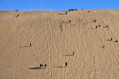 Namibya - 3 Temmuz 2025: Namib-Naukluft Ulusal Parkı, Namibya Afrika 'daki kum tepesinde yürüyen tanımlanamayan turistler