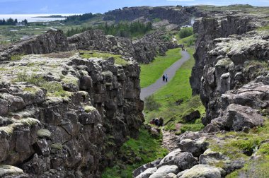 Thingvellir, İzlanda - 31 Temmuz 2024: ziyaretçiler Thingvellir 'deki Almannagja Fayı' na yürüdüler. Thingvellir tarihi kültürel ve jeolojik bir yerdir ve en popüler turizm merkezlerinden biridir.