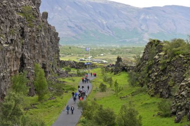 Thingvellir, İzlanda - 31 Temmuz 2024: ziyaretçiler Thingvellir 'deki Almannagja Fayı' na yürüdüler. Thingvellir tarihi kültürel ve jeolojik bir yerdir ve en popüler turizm merkezlerinden biridir.