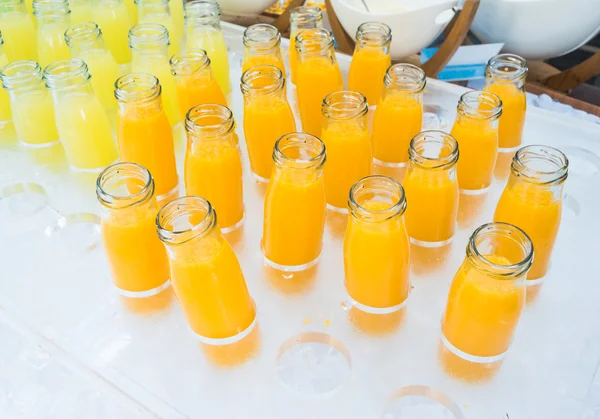 Jugo de naranja fresco y jugo de piña en botellas — Foto de Stock