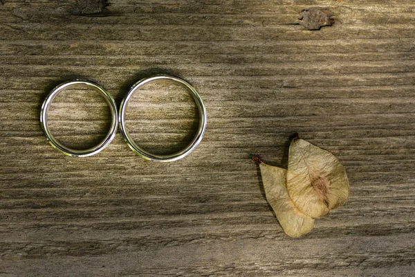 Anéis de casamento de ouro colocados em uma textura de madeira — Fotografia de Stock