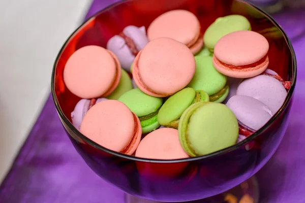 Macarrones rosados, verdes y morados en un plato de vidrio — Foto de Stock