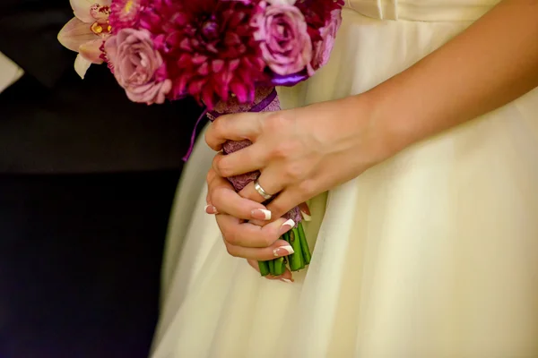 Manos de novia sosteniendo un ramo de rosas — Foto de Stock