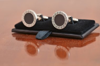 Ahşap yüzey üzerinde siyah kol düğmeleri gümüş yansıma