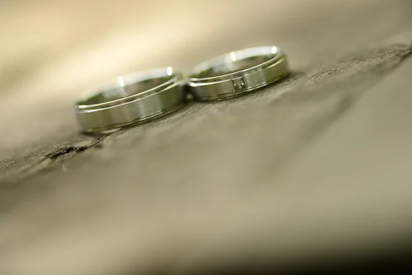 Gold wedding rings placed on a wooden texture — Stock Photo, Image