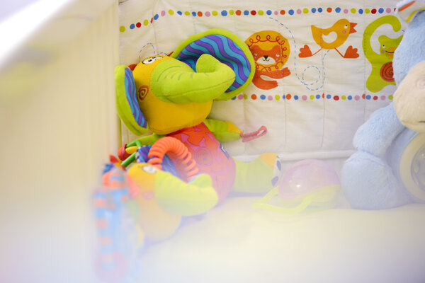 Игрушечный слон сидел в детской кроватке
