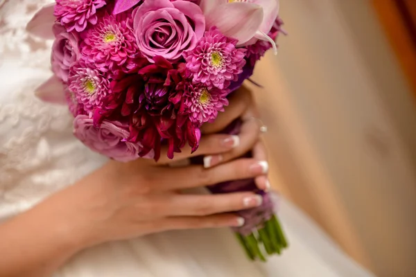 Mariée tenant un bouquet de fleurs rouges — Photo