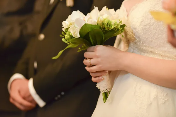 Bride holding a lighted candle and groom in background — Stock Photo, Image