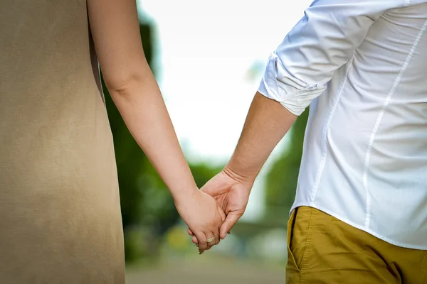 Homme et femme se tiennent la main dans la nature — Photo
