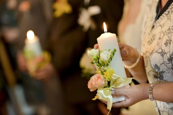 Woman holding a lighted candle in church — Stock Photo, Image