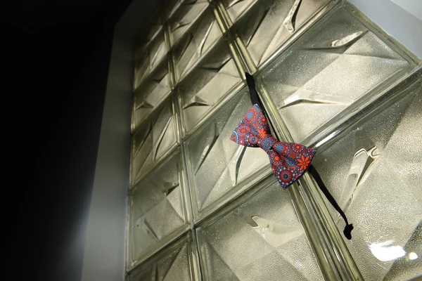 Motýlek s tvarem pověšen na skleněnou stěnu — Stock fotografie