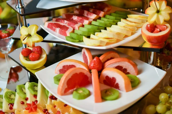 Тарелки с различными видами фруктов: клубника, ананас, апельсин, киви — стоковое фото