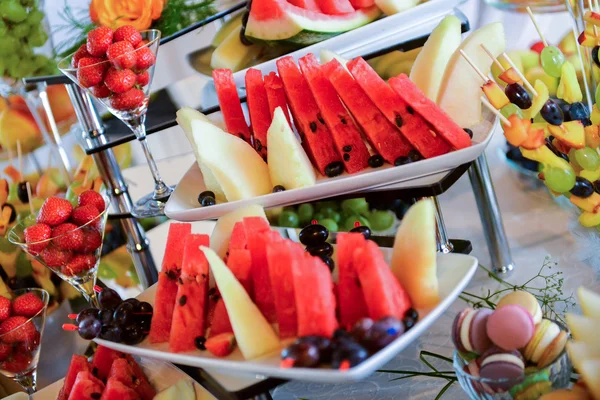 Тарелки с различными видами фруктов: виноград, клубника, ананас, арбуз, абрикосы — стоковое фото