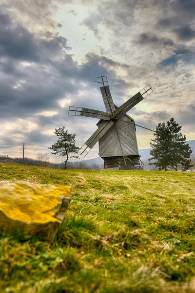 Houten windmolen met gras en dramatische hemel — Stockfoto