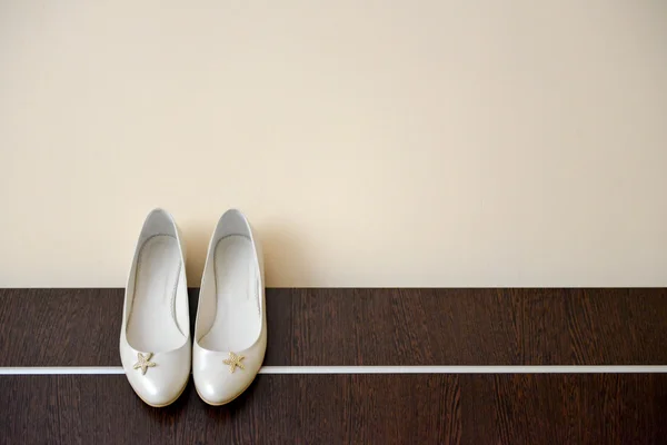 Scarpe bianche di sposa si aggrappa al letto bordo — Foto Stock