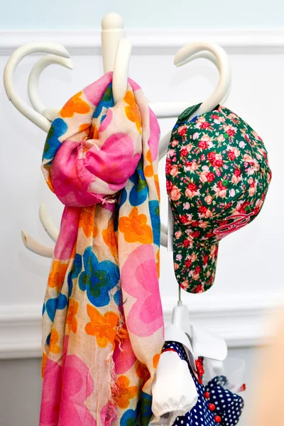 Multicolored colorful scarf and cap hanging on hanger — Stock Photo, Image