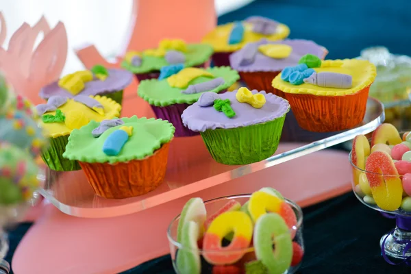 A lot of colorful cupcakes placed on a transparent shelf — Stock Photo, Image