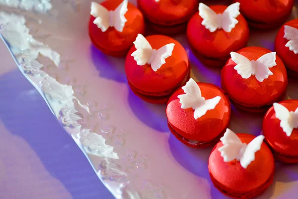 Macarrones rojos con mariposas blancas — Foto de Stock