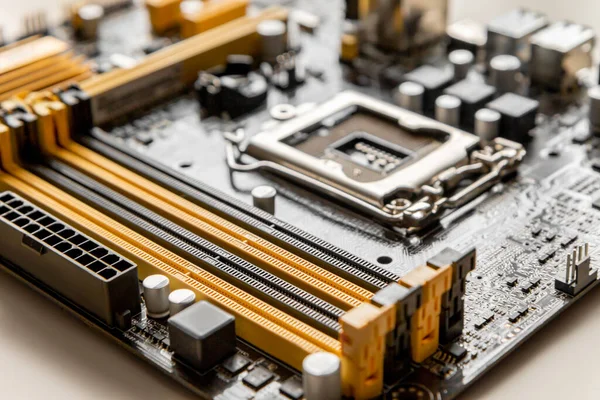 Teil des Mainboards mit Steckplatz zur Platzierung von RAM-Modulen vor dem Hintergrund eines verschwommenen Prozessorsockels. — Stockfoto