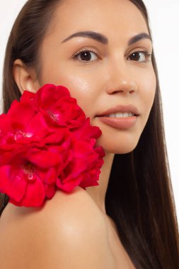 Güzel ciltli, çıplak makyajlı, göz kalemi ve uzun kirpikli, şişkin doğal dudaklı ve beyaz çiçekli bir yüzün yarım portresini kapat. Moda fotoğrafçılığı. Kozmetik ve kaplıca. Baharın tazeliği