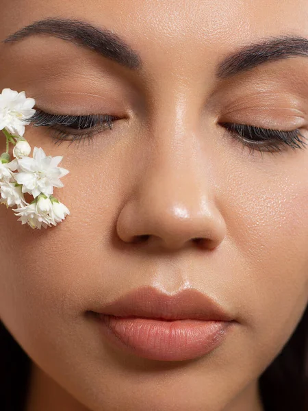 Close-up portrait of a beauty woman with full lips, straight hair and perfectly clean skin. Daytime makeup, styling and soft care. Skin care in the spa salon or cosmetology, smooth eyebrows