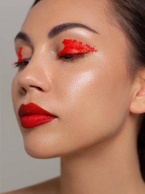 Yeşil gözlü, güzel esmer model kadın yüzü ve mükemmel makyajı kamerada gülümsemesini sağlıyor. Güzelliğin portresi, doğal dudaklar ve göz kalemi, kalın kaş. Açık tenli bir kadın yüzü. Yakın plan..