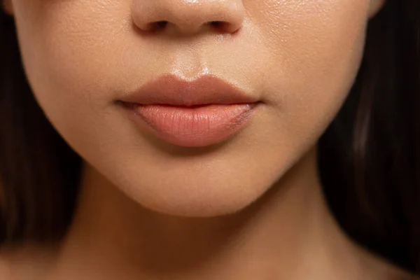 用时尚自然的米黄色口红化妆品对女性嘴唇进行特写 宏观性感苍白的唇彩化妆品 洁白的肌肤和波浪形的黑发 化妆品 嘴唇增加 — 图库照片