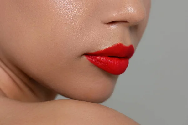 女性嘴唇的特写与时尚鲜红的妆容 美丽的女性嘴 丰满的嘴唇 完美的妆容 女性脸的一部分 选择口红 — 图库照片