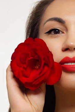 Yaratıcı moda gecesi makyajlı, yarı kadın yüzünün yakın plan güzelliği. Gözlerde siyah oklar ve son derece uzun kirpiklerde, dolgun dudaklarda kırmızı dudak rengi. Kaplıcadan sonra iyi bakımlı cilt